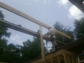 Carpenter setting a ridge beam over a new addition frame — Ice Dam Removal by Roofing Brothers in Donaldsonville