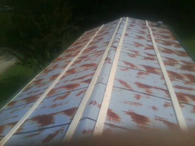 Rusted metal roof panels with new wood purlins before replacement — Storm Damage Roof Repair in Donaldsonville by Roofing Brothers