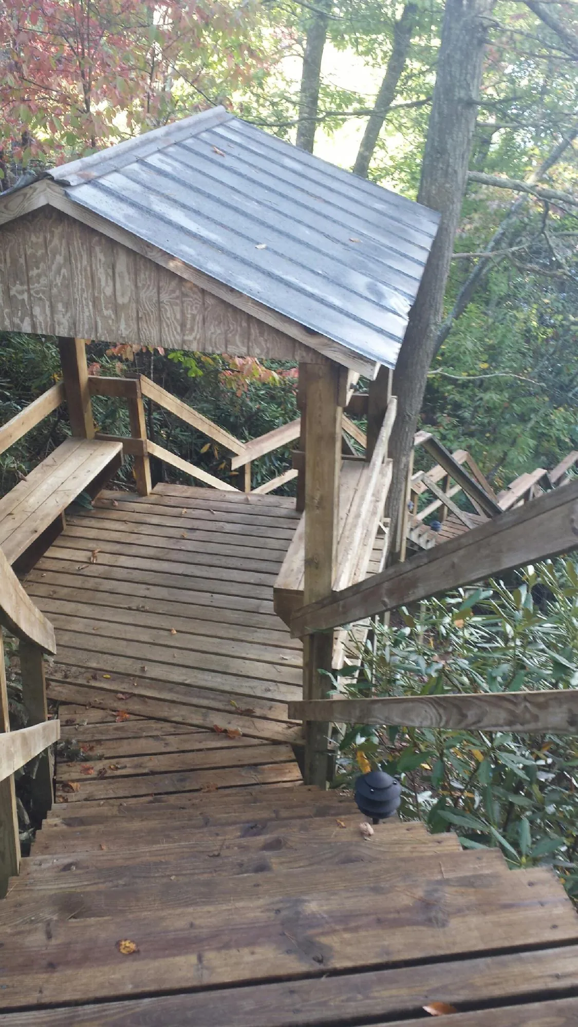 Metal roofed shelter over wooden steps on a wooded walkway — Skylight Repair & Installation work by our crew in Donaldsonville