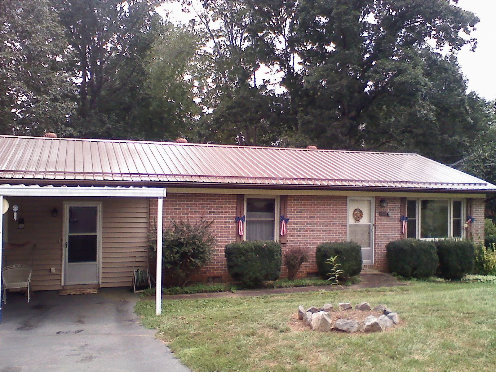 Bronze metal roof and carport on a brick ranch home — Roof Repair work by our crew in Donaldsonville